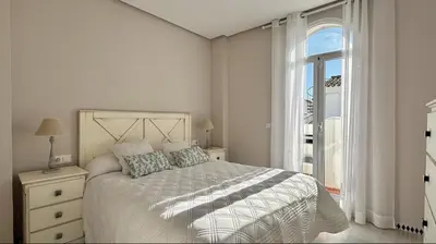 a white bedroom with a bed and a window at Complejo Atlantico in Novo Sancti Petri