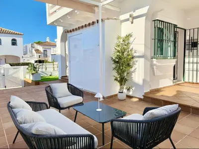 a patio with a table and chairs and a screen at Complejo Atlantico in Novo Sancti Petri