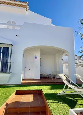 a white house with two chairs and a patio at Complejo Atlantico in Novo Sancti Petri