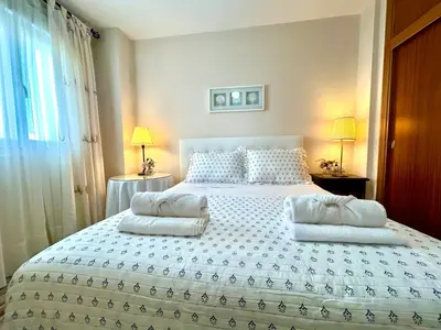 a bedroom with a large white bed with two pillows at GATU Marítimo 