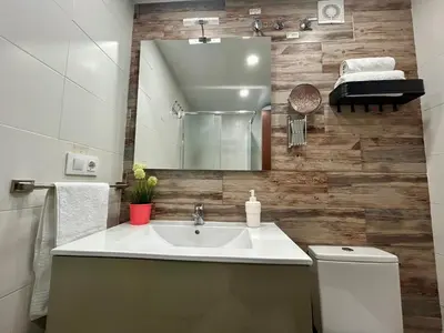 a bathroom with a sink and a mirror and a toilet at GATU Marítimo 
