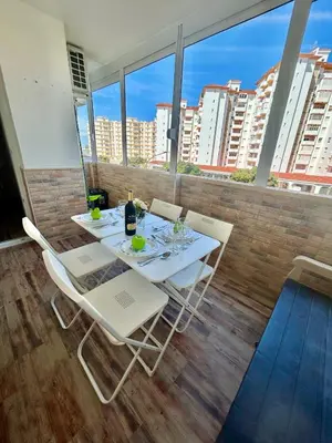 a white table and chairs on a balcony with windows at GATU Marítimo 
