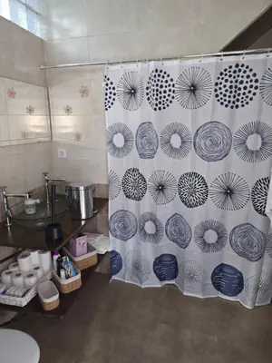 a bathroom with a shower curtain with blue and white at Casa El Canario by Sanlúcar Housing in Sanlúcar de Barrameda