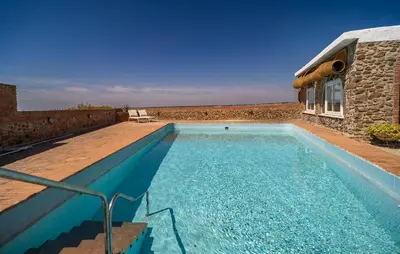 a swimming pool in front of a stone house at Stunning Home In Conil De La Frontera in Conil de la Frontera