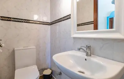 a bathroom with a sink and a toilet and a mirror at Stunning Home In Conil De La Frontera in Conil de la Frontera
