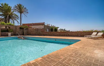 a swimming pool next to a brick wall at Stunning Home In Conil De La Frontera in Conil de la Frontera