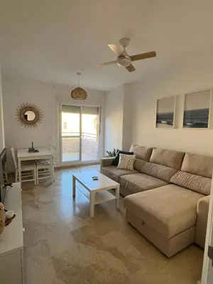 a living room with a couch and a table at Ático en Costa Ballena in Rota