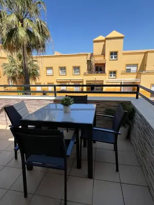 a table and chairs on a balcony with a building at Ático en Costa Ballena in Rota