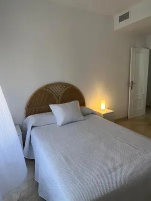 a bedroom with a large bed with a white bedspread at Ático en Costa Ballena in Rota