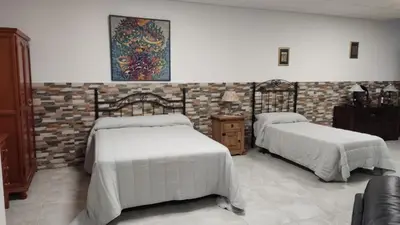 a bedroom with two beds and a brick wall at Loft los olivos in Algar