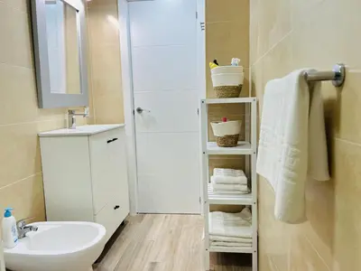 a white bathroom with a sink and a mirror at Mi casa vacacional en Valdelagrana in El Puerto de Santa María