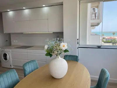 a vase with flowers on a table in a kitchen at Mi casa vacacional en Valdelagrana in El Puerto de Santa María