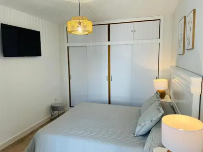 a small bedroom with a bed and a tv at Mi casa vacacional en Valdelagrana in El Puerto de Santa María