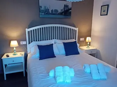 a bedroom with a white bed with blue pillows at Casa Patricia I in Arcos de la Frontera