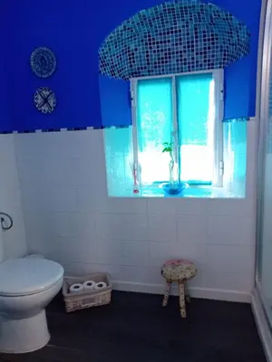 a blue bathroom with a toilet and a window at Casa Patricia I in Arcos de la Frontera