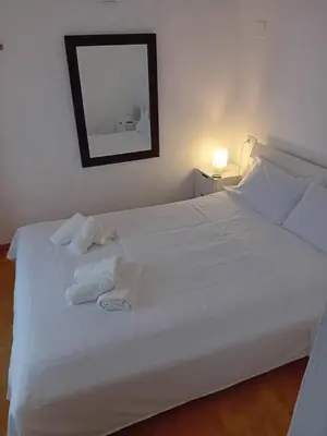 a bedroom with a white bed with towels on it at Casa Patricia II in Arcos de la Frontera