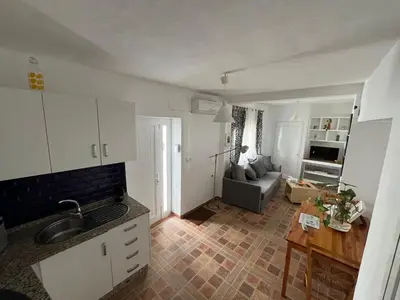 a kitchen and living room with a couch and a table at Casa Patricia II in Arcos de la Frontera