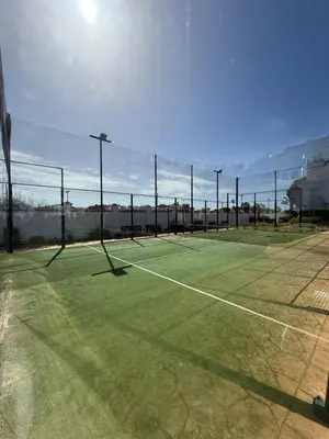 a tennis court with a net on top of it at Mi sueño free parking by staycare in Rota