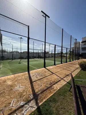 a tennis court with a net on a field at Mi sueño free parking by staycare in Rota