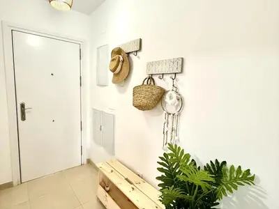 a living room with a bench and a door at Mi sueño free parking by staycare in Rota