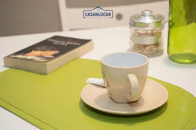a green tray with a coffee cup and a book at Atico Molinillo in Sanlúcar de Barrameda