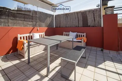 a table and chairs on a rooftop patio at Atico Molinillo in Sanlúcar de Barrameda