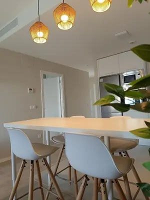 a dining room table with white chairs and lights at Ocean Home - Costa Ballena in Costa Ballena