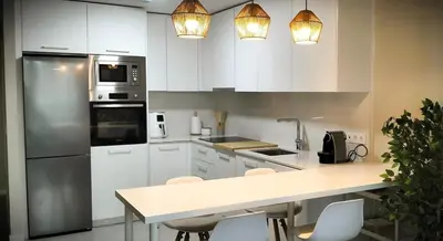 a kitchen with white cabinets and stainless steel appliances at Ocean Home - Costa Ballena in Costa Ballena