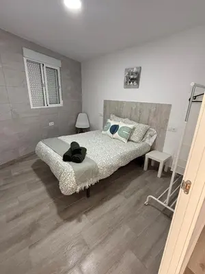 a bedroom with a bed and a wooden floor at Apartamento Bf Jerez in Jerez de la Frontera