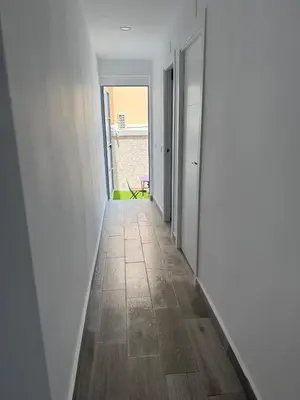 an empty hallway with white walls and a wooden floor at Apartamento Bf Jerez in Jerez de la Frontera