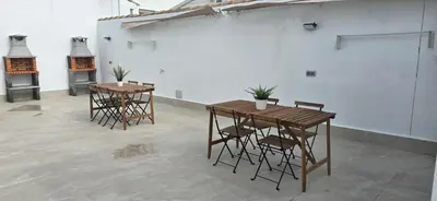 two tables and chairs in a room with a white wall at Chiclanafactory in Chiclana de la Frontera