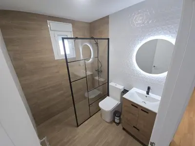 a bathroom with a toilet and a sink and a mirror at Chiclanafactory in Chiclana de la Frontera