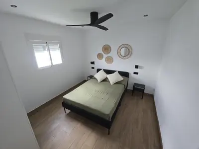 a white bedroom with a bed and a window at Chiclanafactory in Chiclana de la Frontera