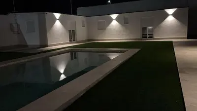 a swimming pool in a room with a green lawn at Chiclanafactory in Chiclana de la Frontera