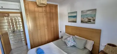 a bedroom with a bed with a wooden headboard at El Ancla in Novo Sancti Petri