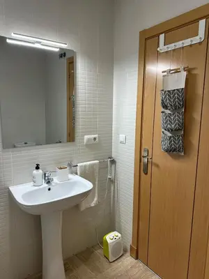 a bathroom with a white sink and a mirror at El Ancla in Novo Sancti Petri