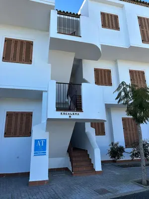 an apartment building with a staircase in front of it at El Ancla in Novo Sancti Petri