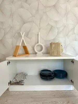 a white shelf with blue plates and a wall at El Ancla in Novo Sancti Petri