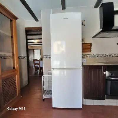a white refrigerator in a kitchen with a hallway at la petit in Chiclana de la Frontera