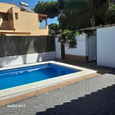 a swimming pool in front of a house at la petit in Chiclana de la Frontera