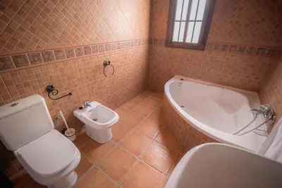 a bathroom with a toilet and a tub and a bidet at Casa Rural Manuel Sevillano in Bornos