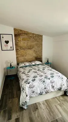 a bedroom with a bed and two end tables at Precioso Apartamento Centro Jerez in Jerez de la Frontera