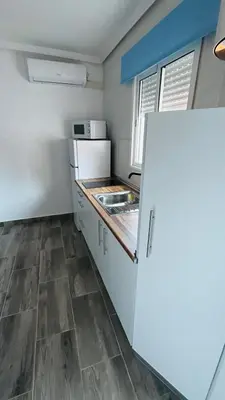a kitchen with a white refrigerator and a counter at Precioso Apartamento Centro Jerez in Jerez de la Frontera