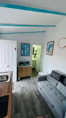 a living room with a couch and a kitchen at Precioso Apartamento Centro Jerez in Jerez de la Frontera