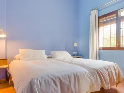 a bedroom with a large white bed with a window at Villa La Vega 14354 in Chiclana de la Frontera