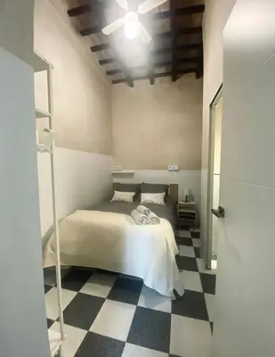 a bedroom with a bed and a checkered floor at Apartamento Moraito Chico in Jerez de la Frontera