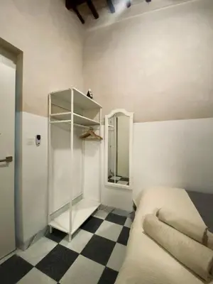 a bedroom with a bed and a mirror and a checkered floor at Apartamento Moraito Chico in Jerez de la Frontera