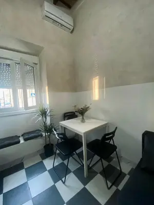 a dining room with a white table and chairs at Apartamento Moraito Chico in Jerez de la Frontera