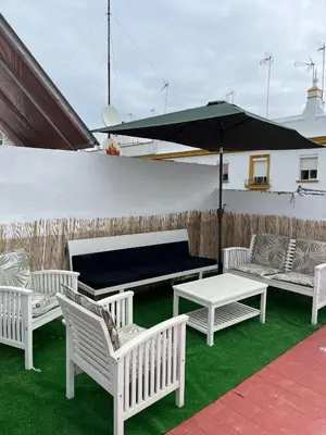 a group of white chairs and a table and an umbrella at Centrally located apartment with terrace in El Puerto de Santa María