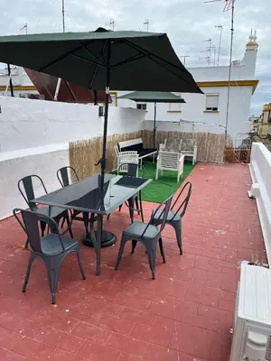 a table and chairs with an umbrella on a patio at Centrally located apartment with terrace in El Puerto de Santa María